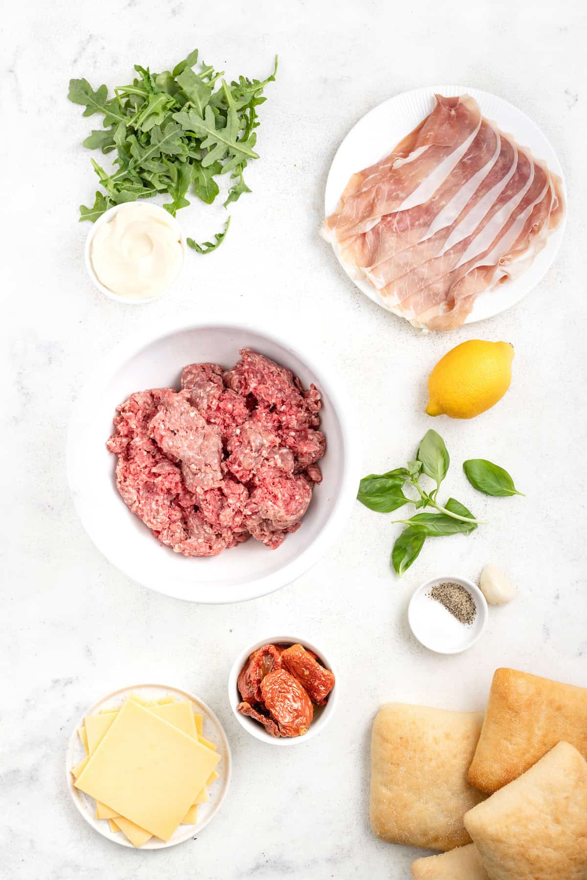 This 15-minute Italian cheeseburger is loaded with gouda cheese, sun-dried tomatoes, pesto aioli, and prosciutto for the perfect bite. Ingredients for the Italian burger.