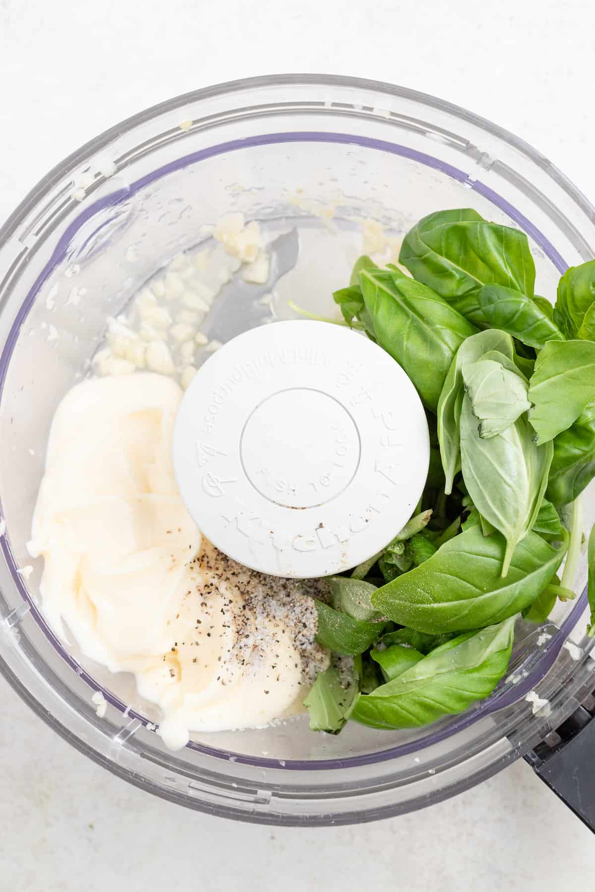 Adding the aioli ingredients to the food processor. 