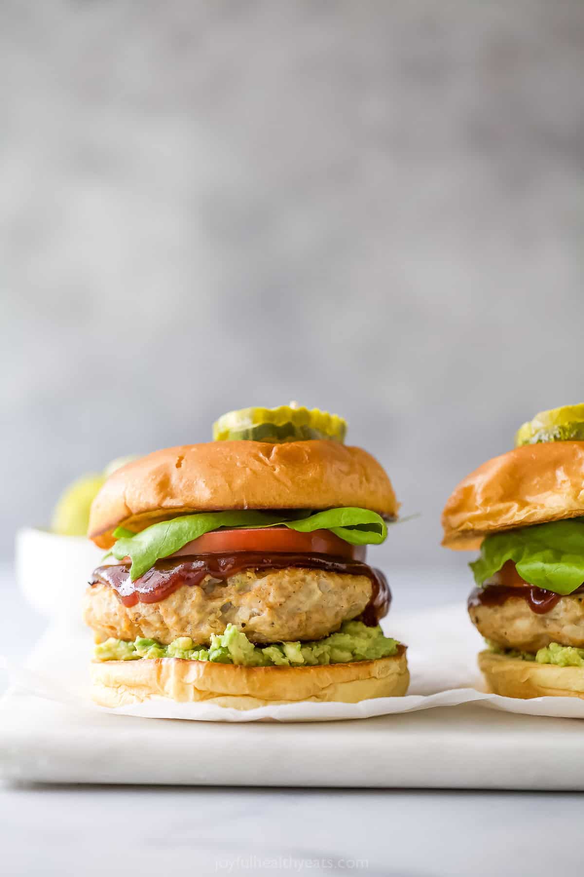 These BBQ Chicken Burgers are easy to make and perfect for summer parties and weeknight dinners. So flavorful and juicy! Chicken burger with BBQ sauce, lettuce, avocado, and tomato