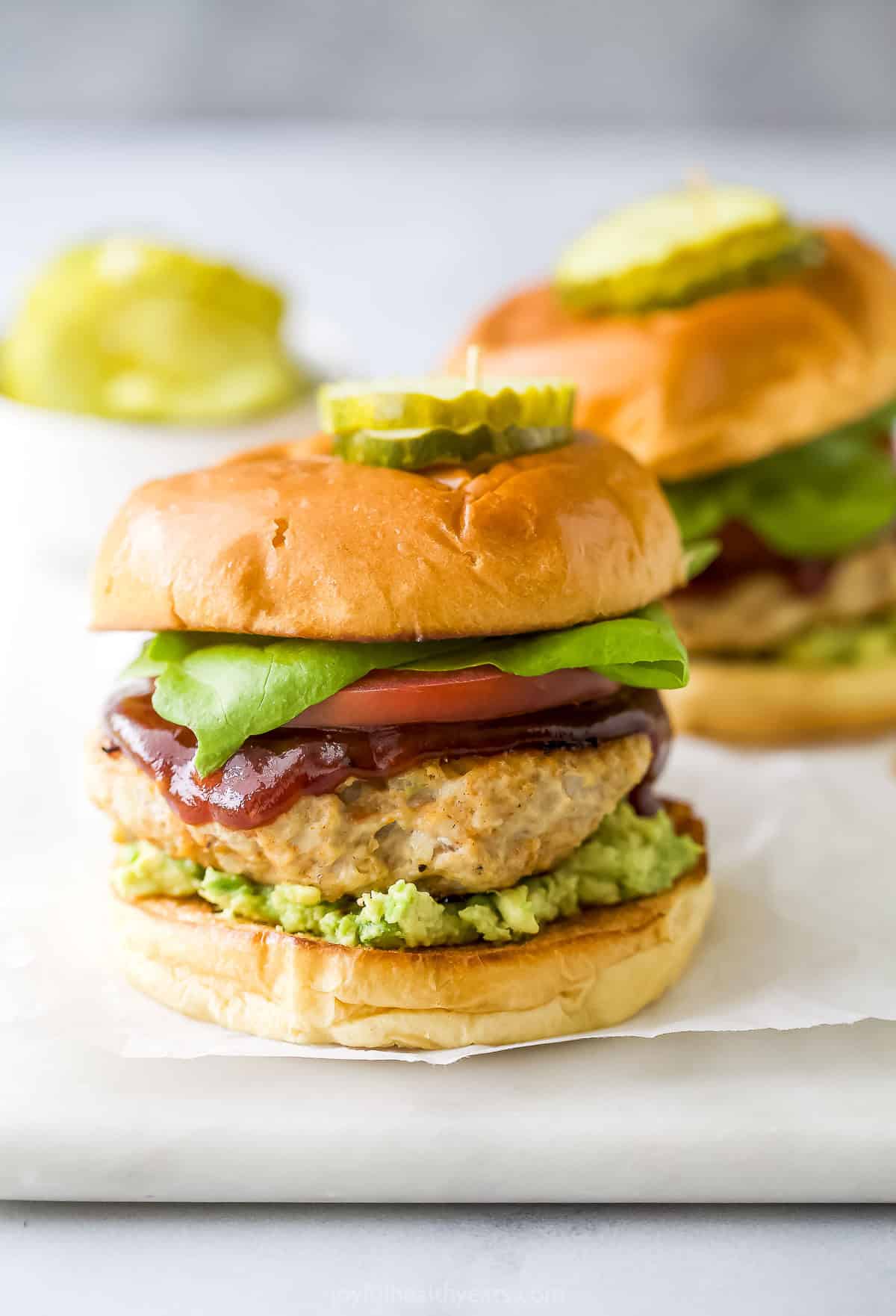 These BBQ Chicken Burgers are easy to make and perfect for summer parties and weeknight dinners. So flavorful and juicy! Juicy BBQ chicken burgers on marble board
