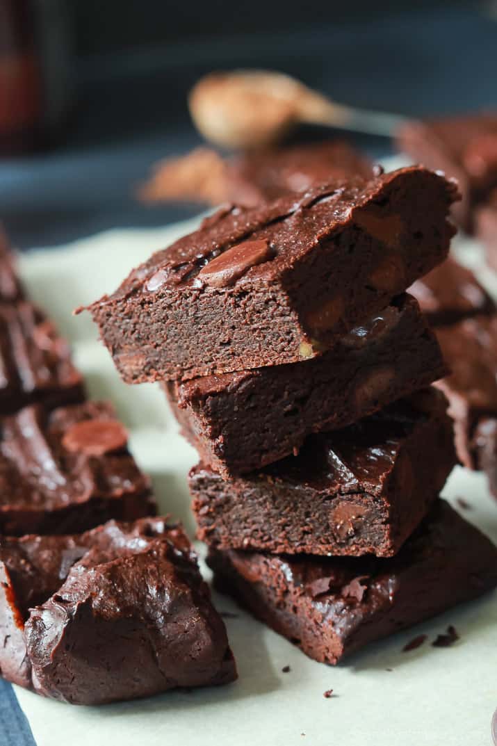 Close-up of a stack of Fudgy Avocado Brownies on parchment paper