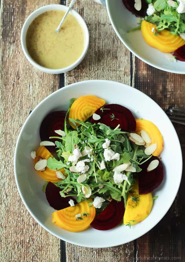 Roasted Beet Arugula Salad with sliced almonds, fresh thyme, and creamy goat cheese then drizzled with a honey dijon vinaigrette - the perfect light salad for your weekend party! Takes minutes to make! | joyfulhealthyeats.com #recipes #vegetarian #glutenfree