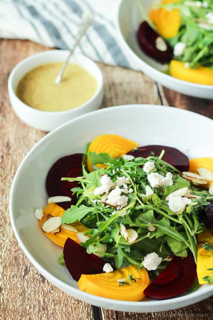 Roasted Beet Arugula Salad with sliced almonds, fresh thyme, and creamy goat cheese then drizzled with a honey dijon vinaigrette - the perfect light salad for your weekend party! Takes minutes to make! | joyfulhealthyeats.com #recipes #vegetarian #glutenfree