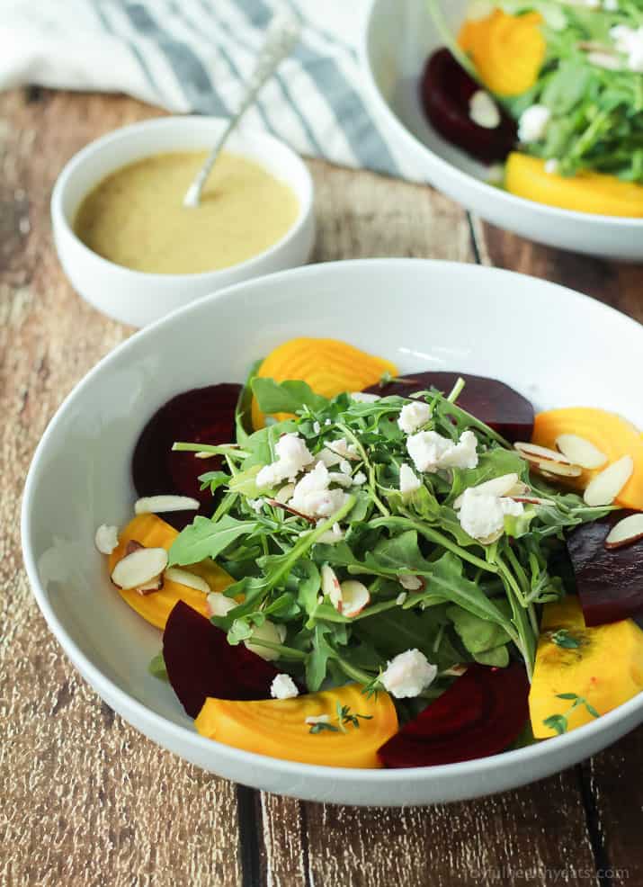 Roasted Beet Arugula Salad with sliced almonds, fresh thyme, and creamy goat cheese then drizzled with a honey dijon vinaigrette - the perfect light salad for your weekend party! Takes minutes to make! | joyfulhealthyeats.com #recipes #vegetarian #glutenfree