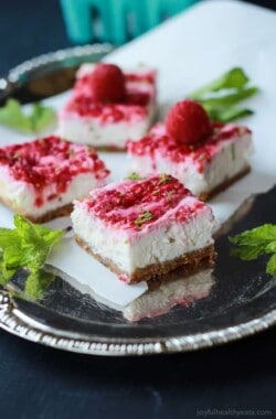 Skinny Raspberry Mojito Cheesecake Bars filled with creamy cheesecake goodness, fresh mint and lime juice, then topped with a fresh raspberry compote - only 130 calories! Perfect for summer parties! | joyfulhealthyeats.com #RaspberryDessert #Driscollsberry #ad