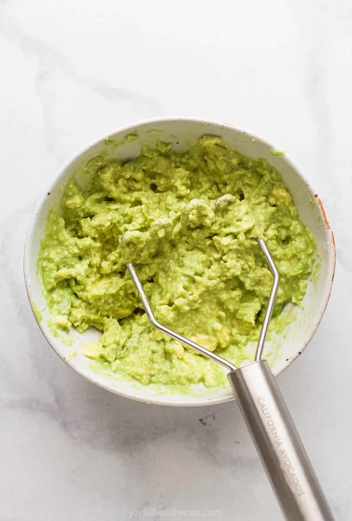 Mashed guacamole in a bowl.