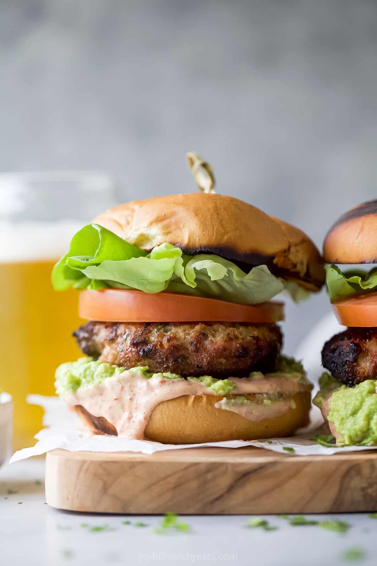 This 20-minute turkey burger with piquillo mayo and guacamole will be your new favorite summer recipe. It's perfect for cookouts! Two turkey burgers side by side.
