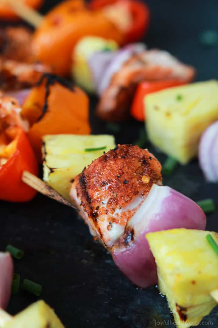 Close-up view of Caribbean Grilled Salmon Kabobs with cajun spices, fresh pineapple, bell peppers, and fresh seafood