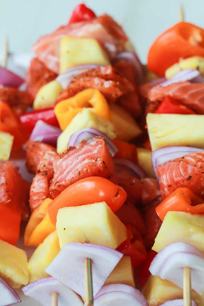 Uncooked Caribbean Grilled Salmon Kabobs with the cajun spices, fresh pineapple, bell peppers, and fresh seafood
