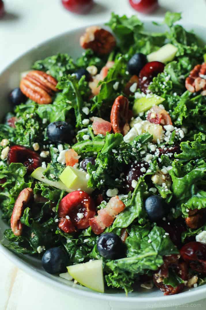 Close-up of Summer Kale Salad with fresh cherries and blueberries, pecans, bacon and feta in a serving bowl