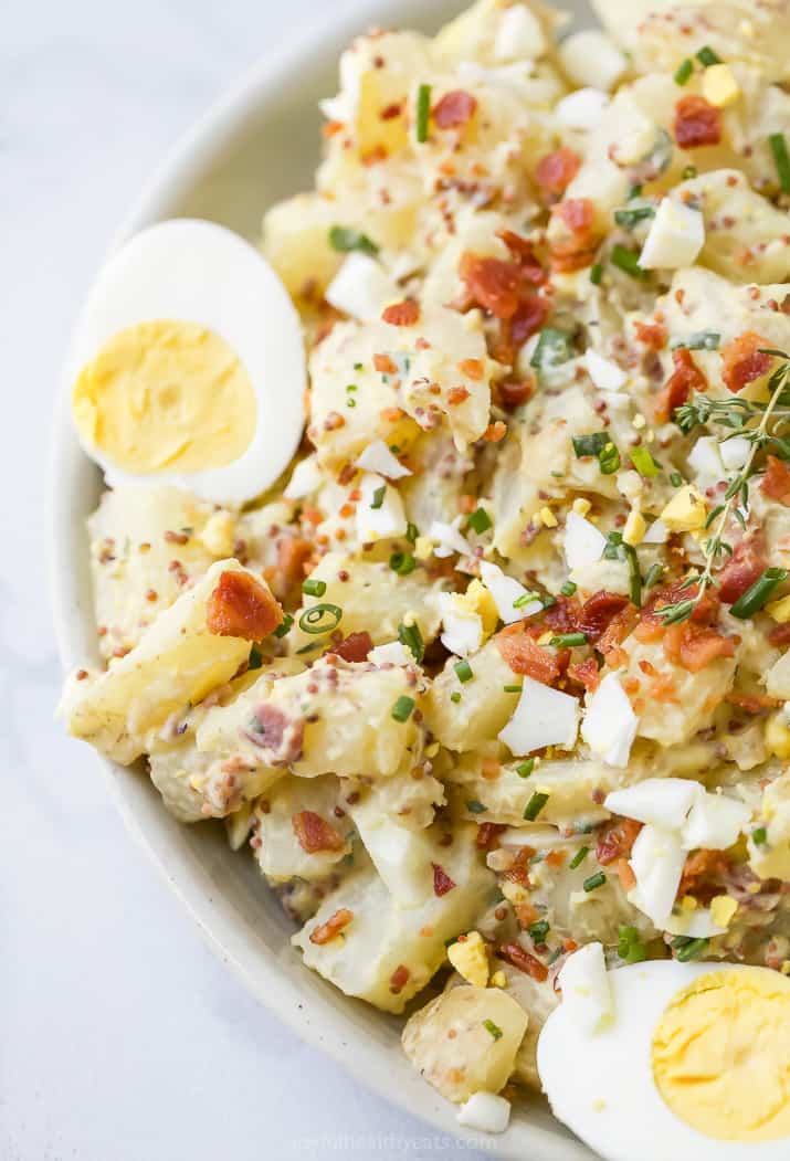 close up photo of creamy easy potato salad with yogurt mustard sauce and bacon