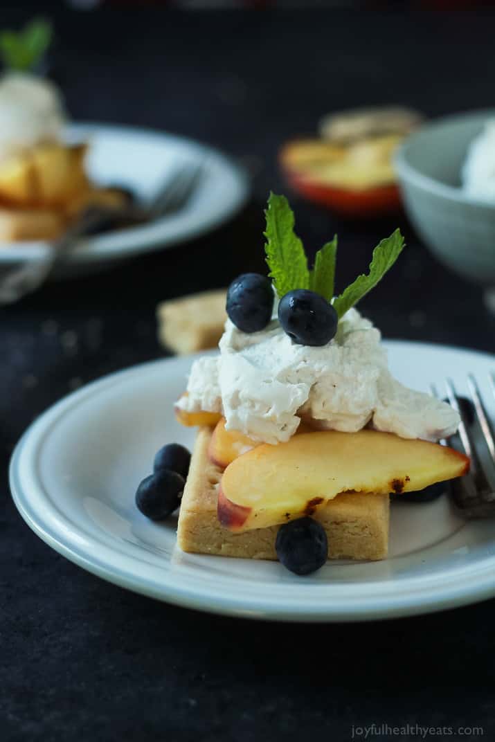 Grilled Peach Shortcake with buttery shortbread, grilled peaches, and coconut whipped cream on a plate