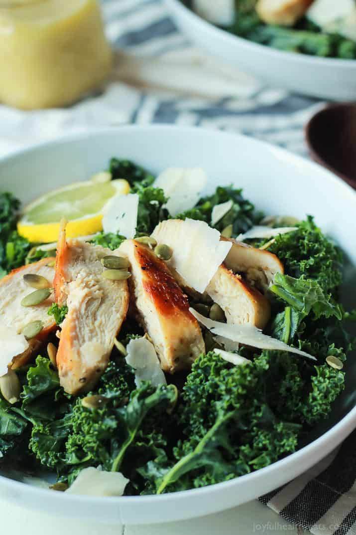 Easy Kale Chicken Caesar Salad with pepitas, shaved parmesan and a homemade egg and anchovy free Caesar Dressing! Its the perfect salad recipe to have for the summer! | joyfulhealthyeats.com 