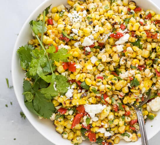 spoon scooping some summer corn salad out of a bowl
