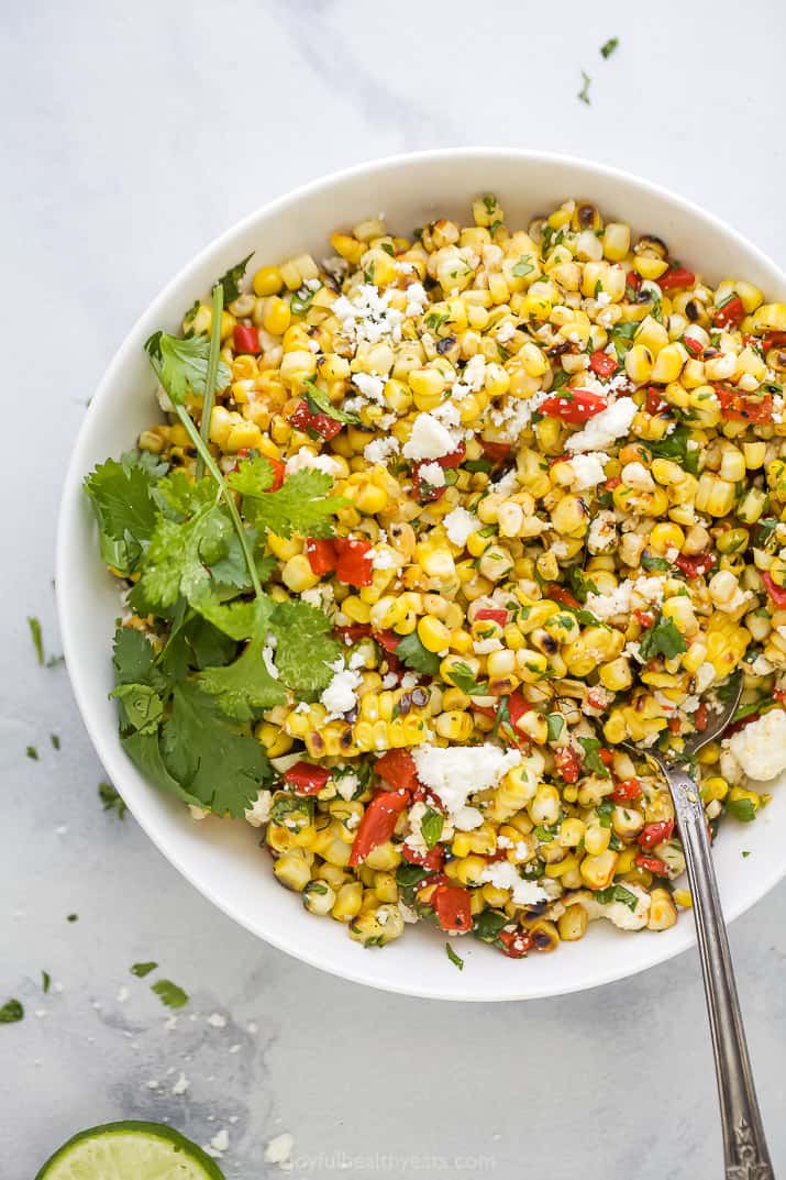 spoon scooping some summer corn salad out of a bowl