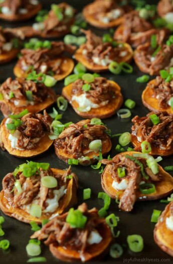 BBQ Pulled Pork Sweet Potato Bites are sure to be a family favorite. Topped with creamy whipped goat cheese and moist BBQ Pulled Pork with a few secret ingredients - you'll be addicted after one! | joyfulhealthyeats.com #appetizer #gameday #recipes