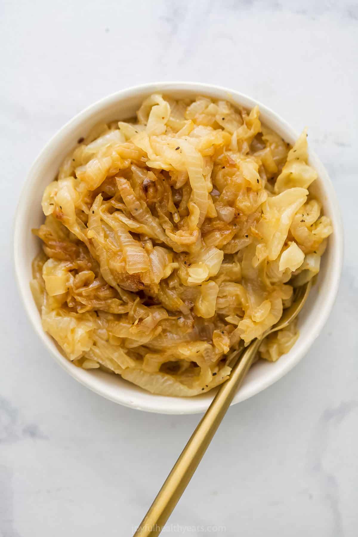Bowl of caramelized onions with spoon.