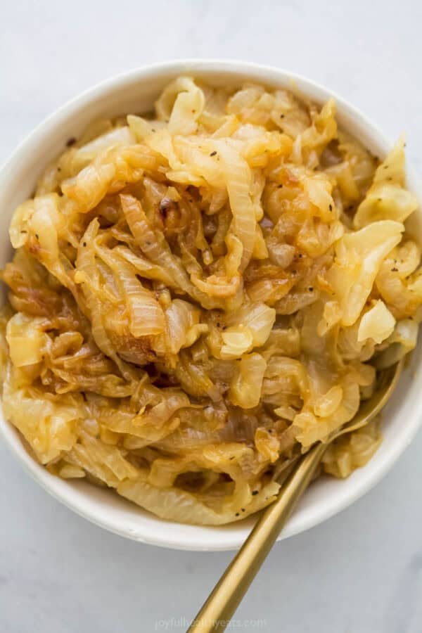 Bowl of caramelized onions with spoon.