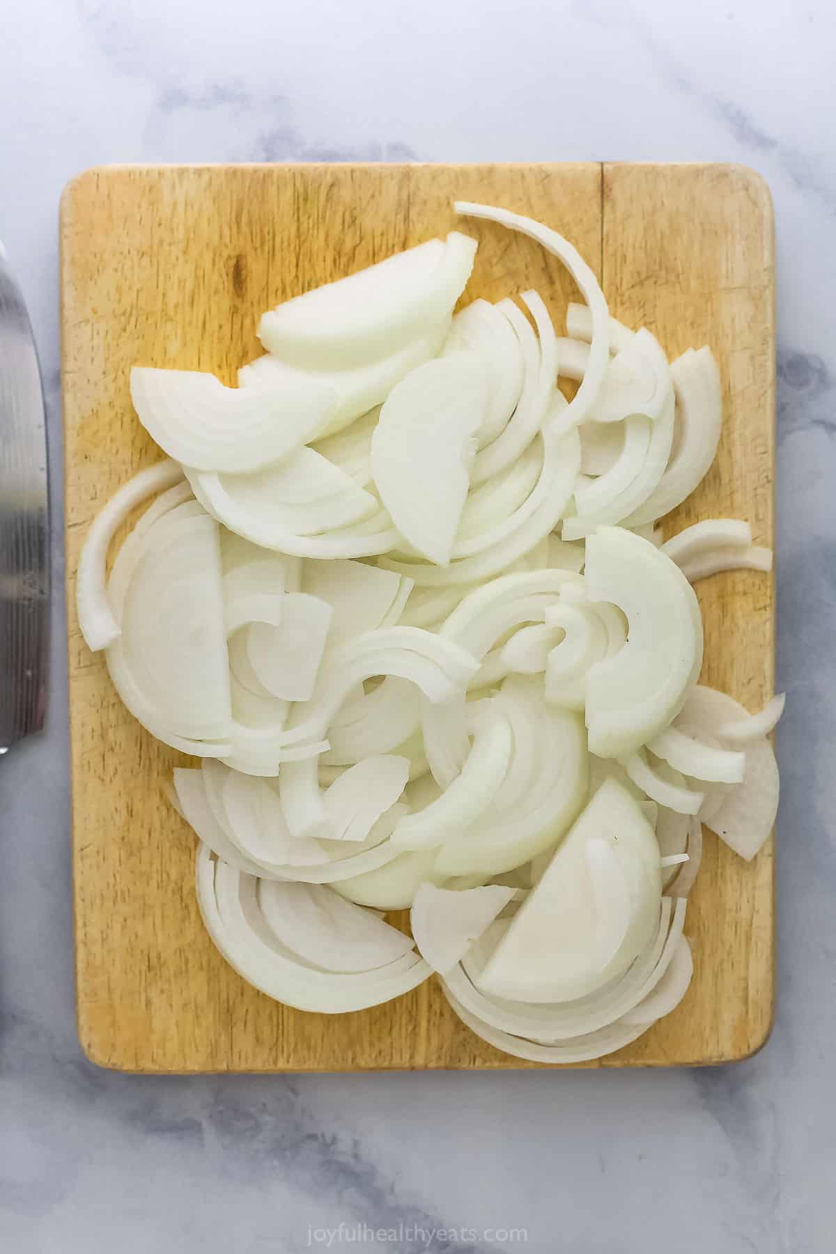 Sliced onions on cutting board.