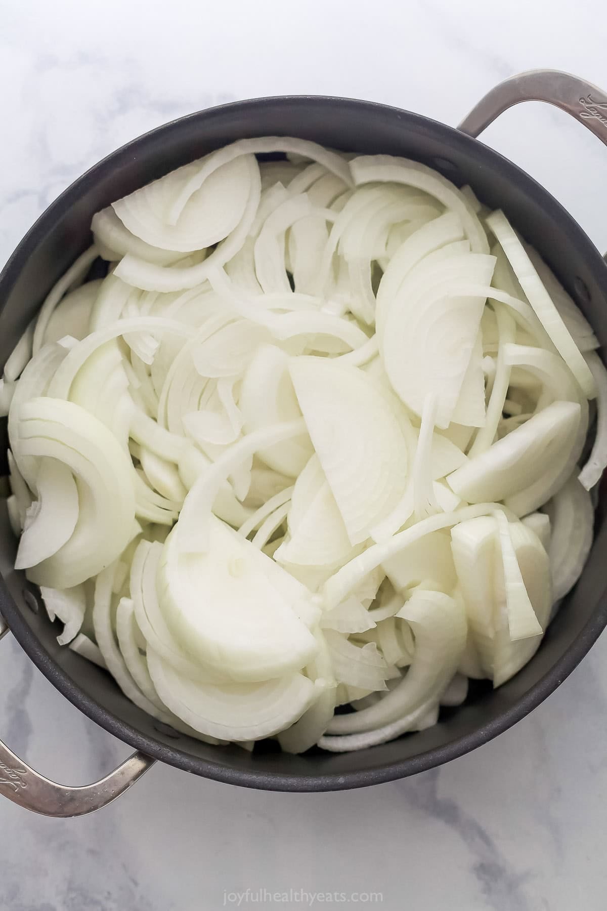 Raw onions added to skillet.