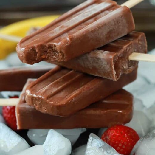 Four homemade fudge pops stacked on top of each other with the top one missing a bite