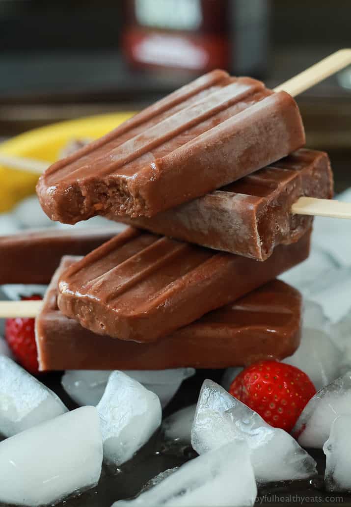 A stack of Chocolate Banana Split Popsicles with a bite out of the top one