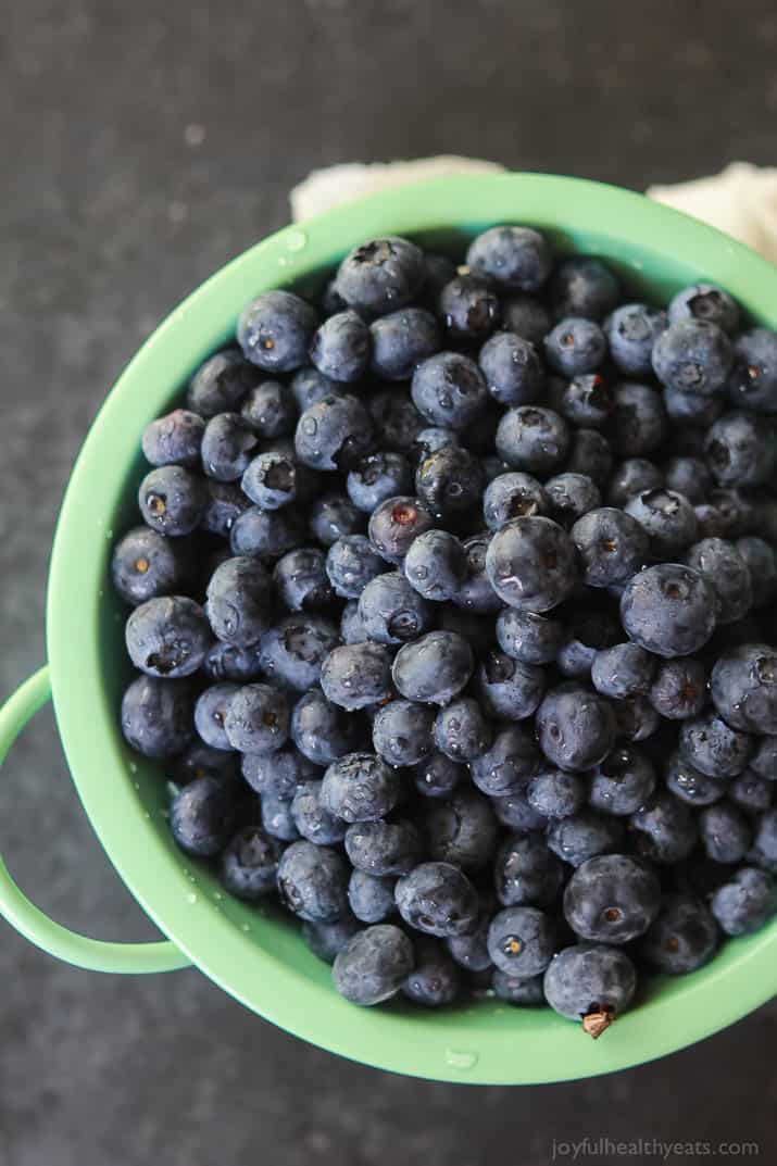 A strainer full of fresh blueberries after they've been rinsed