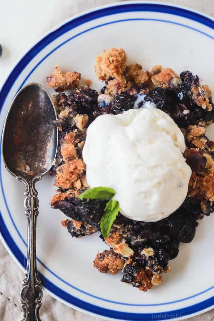 Top view of a serving of Ginger Blueberry Crisp with vanilla ice cream on a plate