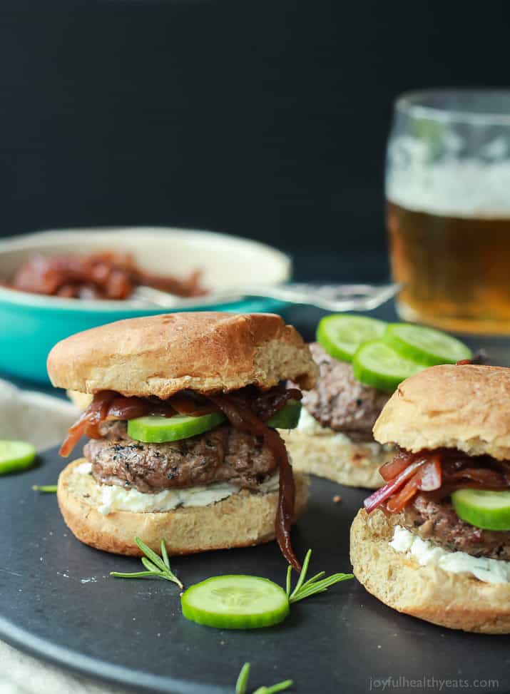 Grilled Lamb Burgers topped with whipped feta cheese, cucumber, and balsamic caramelized onions