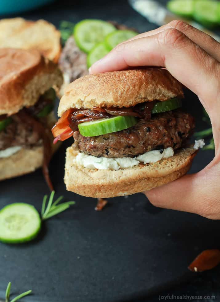 Close-up view of Grilled Lamb Burgers with whipped feta cheese, cucumber, and balsamic caramelized onions