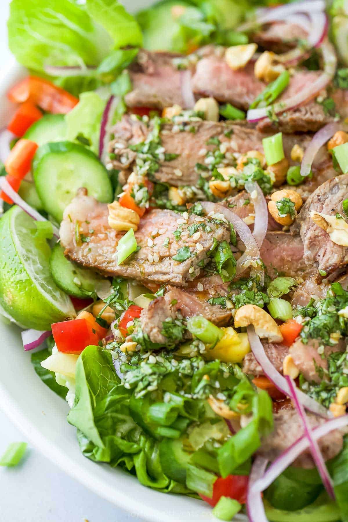 Thai steak salad in bowl with sesame dressing.