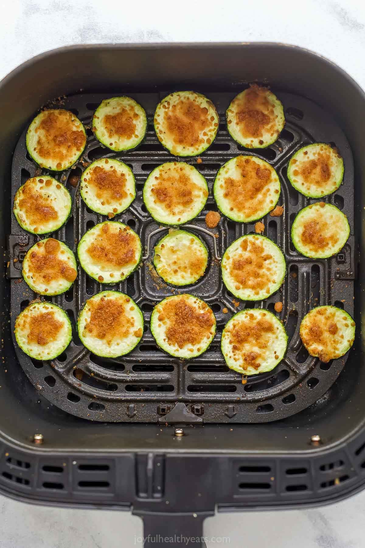 Overhead view of zucchini chips in air fryer