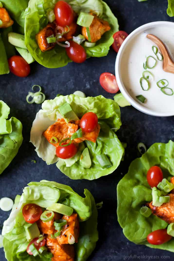 Top view of several Grilled Buffalo Chicken Lettuce Wraps with a bowl of creamy dressing