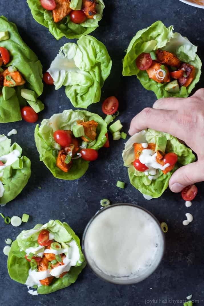 Top view of several Grilled Buffalo Chicken Lettuce Wraps with a bowl of creamy dressing