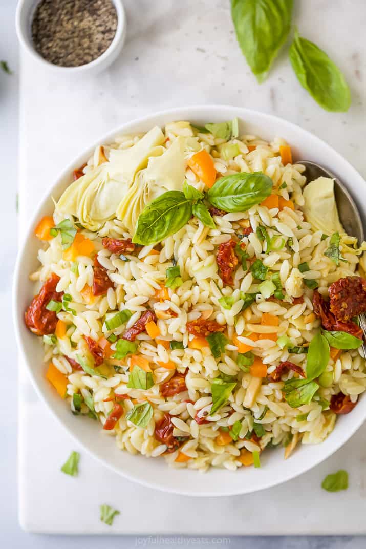 A White Bowl Filled with Mediterranean Pasta Salad on a Placemat