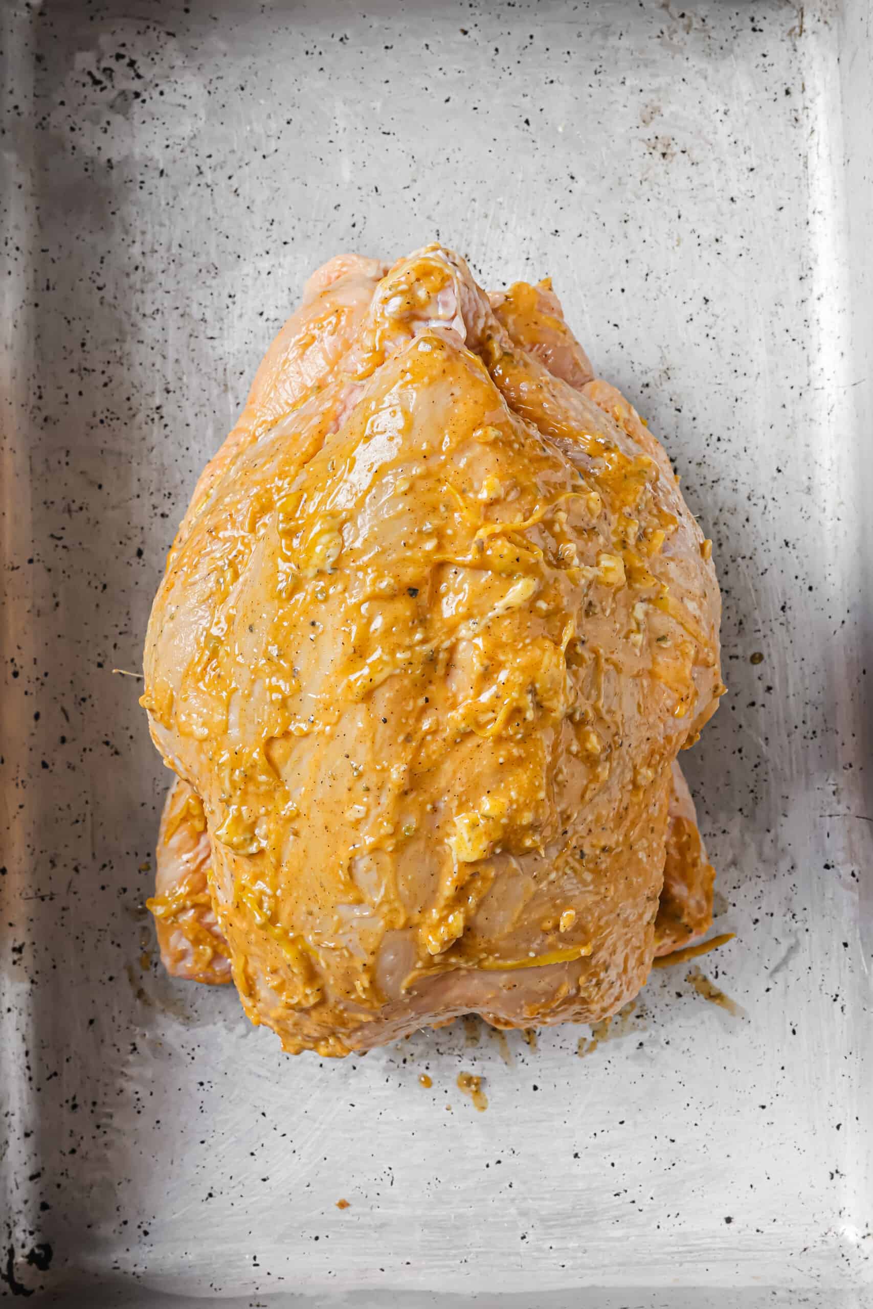 Rubbing the flavored butter on the chicken. 