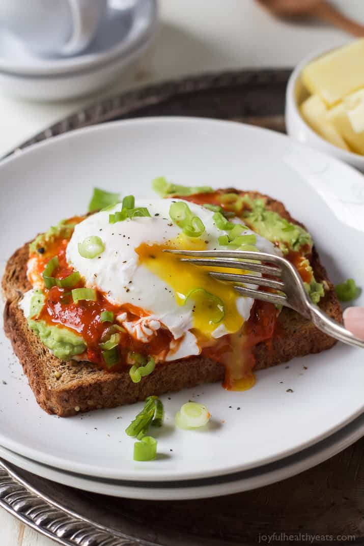 A Piece of Ricotta Avocado Toast Topped with Harissa and a Poached Egg