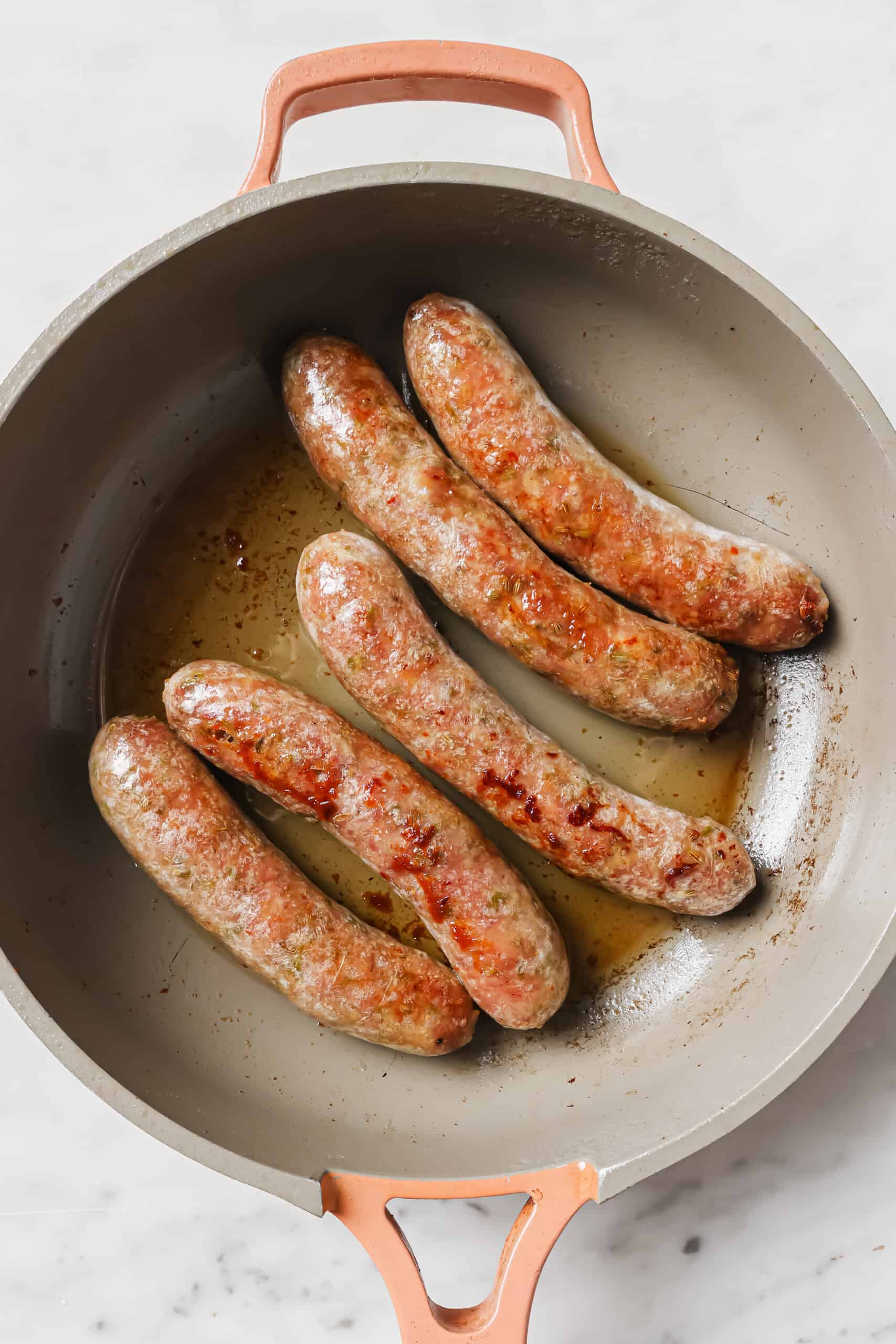 Browned sausage in the skillet. 