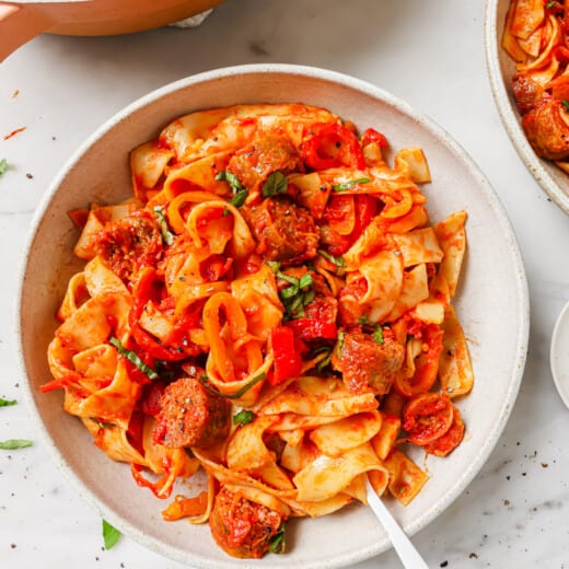 Pappardelle pasta in a bowl with parmesan and basil.