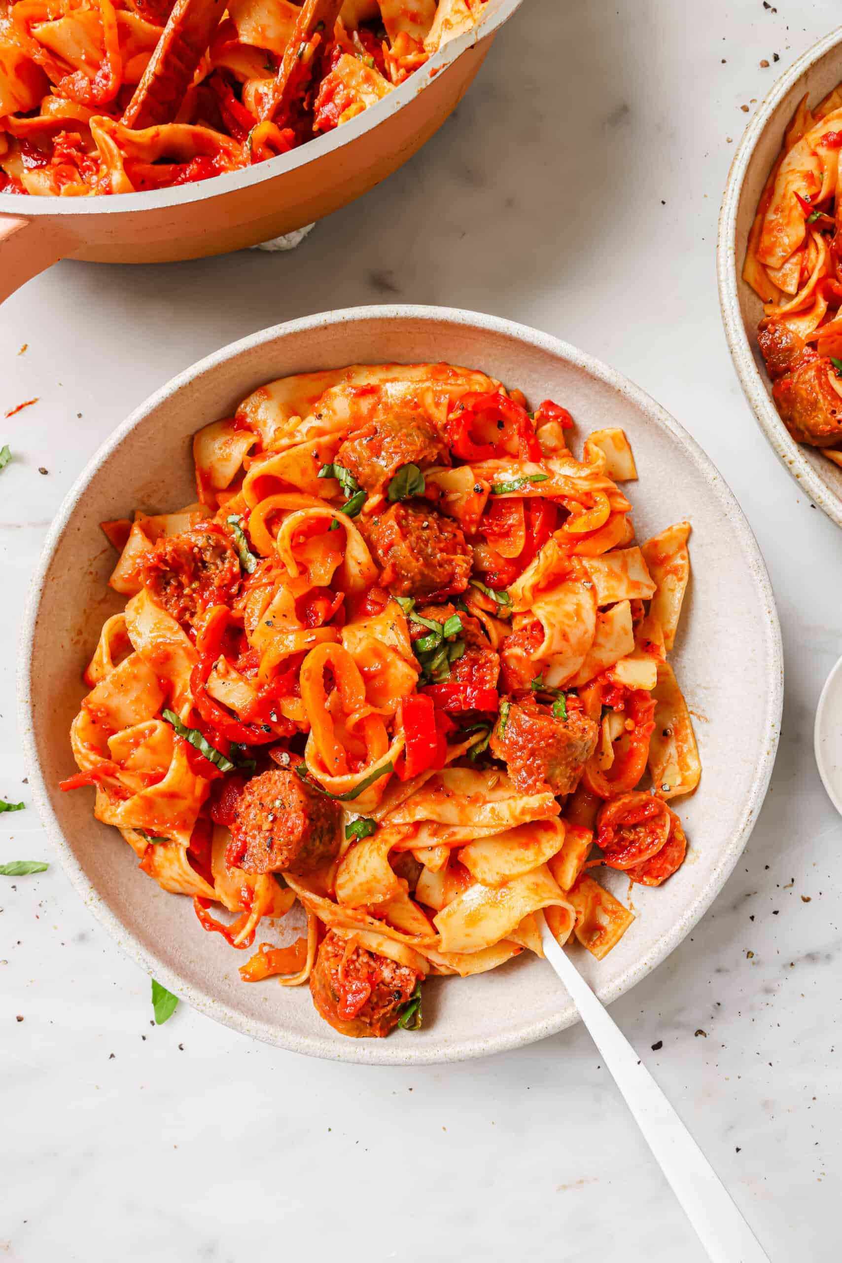 Pappardelle pasta in a bowl with parmesan and basil.