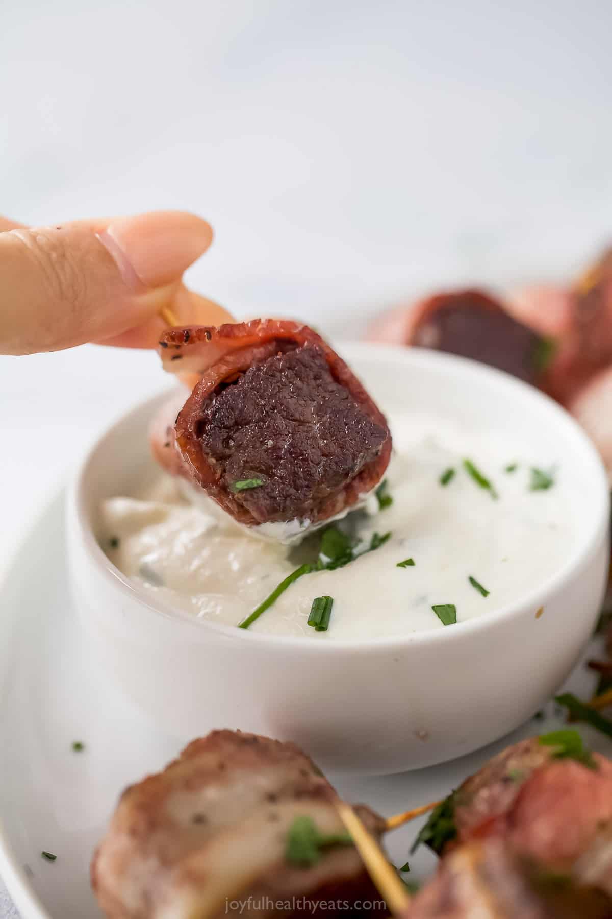 Dipping a steak bite into the creamy sauce. 