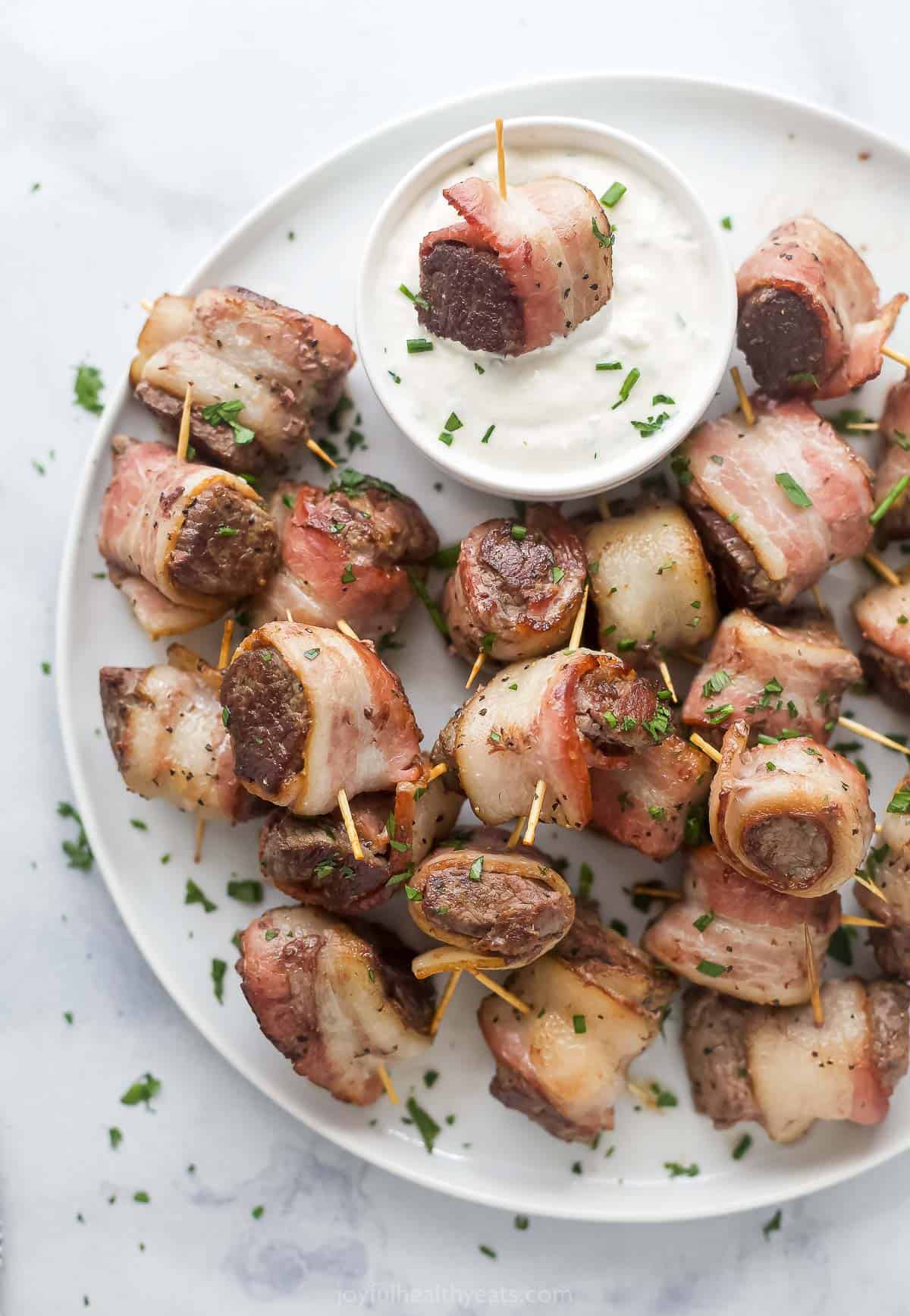 Plate with beef tenderloin bites and horseradish sauce on the side. 