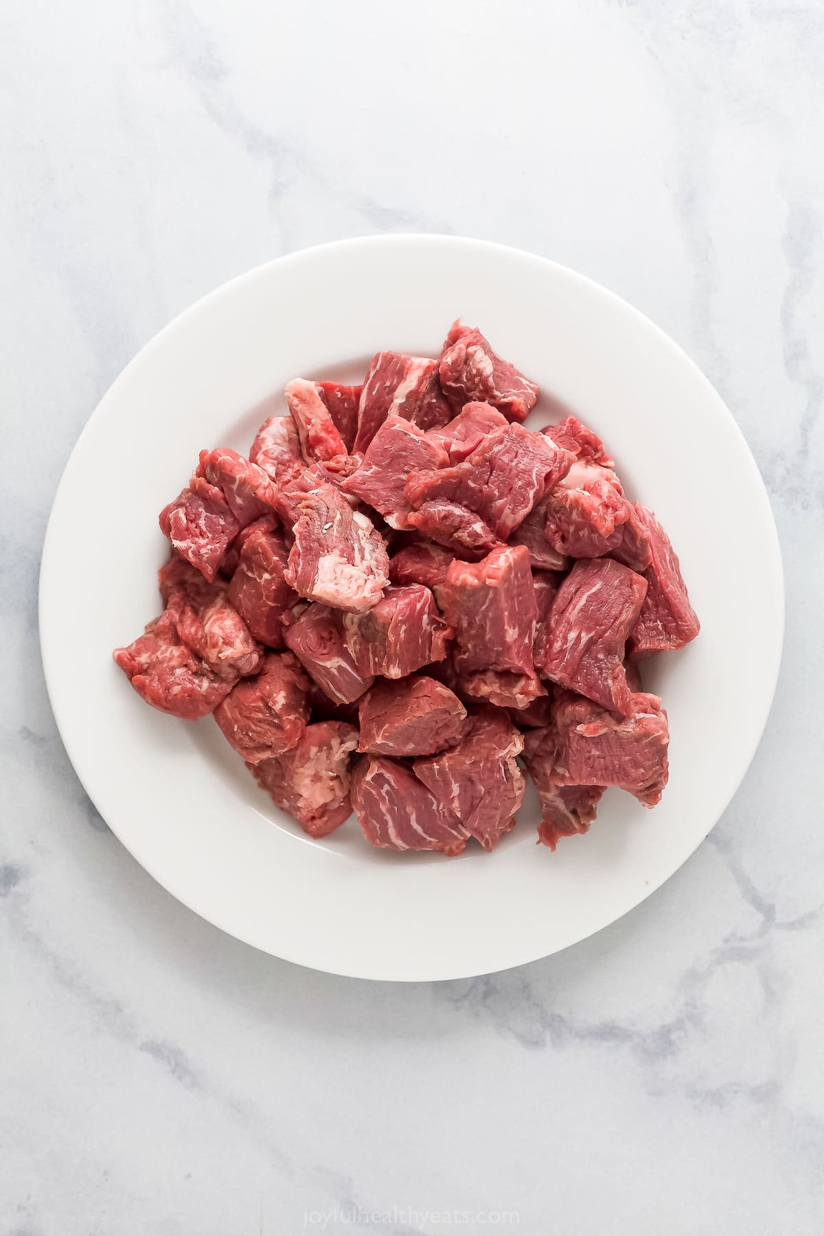 Seasoning the diced beef with salt. 