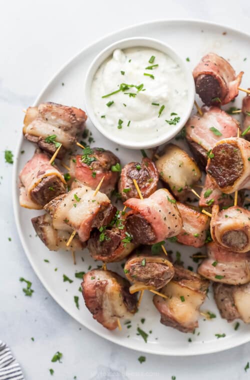 Plate of juicy steak bites with horseradish sauce.