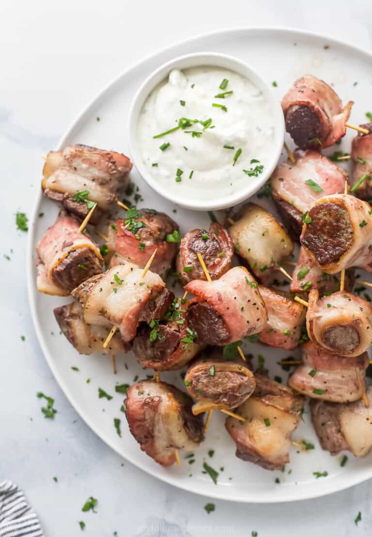 Plate of juicy steak bites with horseradish sauce.