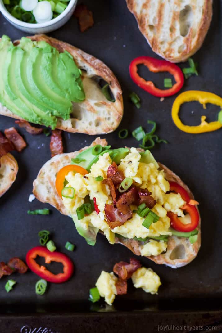 A Piece of Regular Avocado Toast Beside a Piece of Bruschetta on Avocado Toast