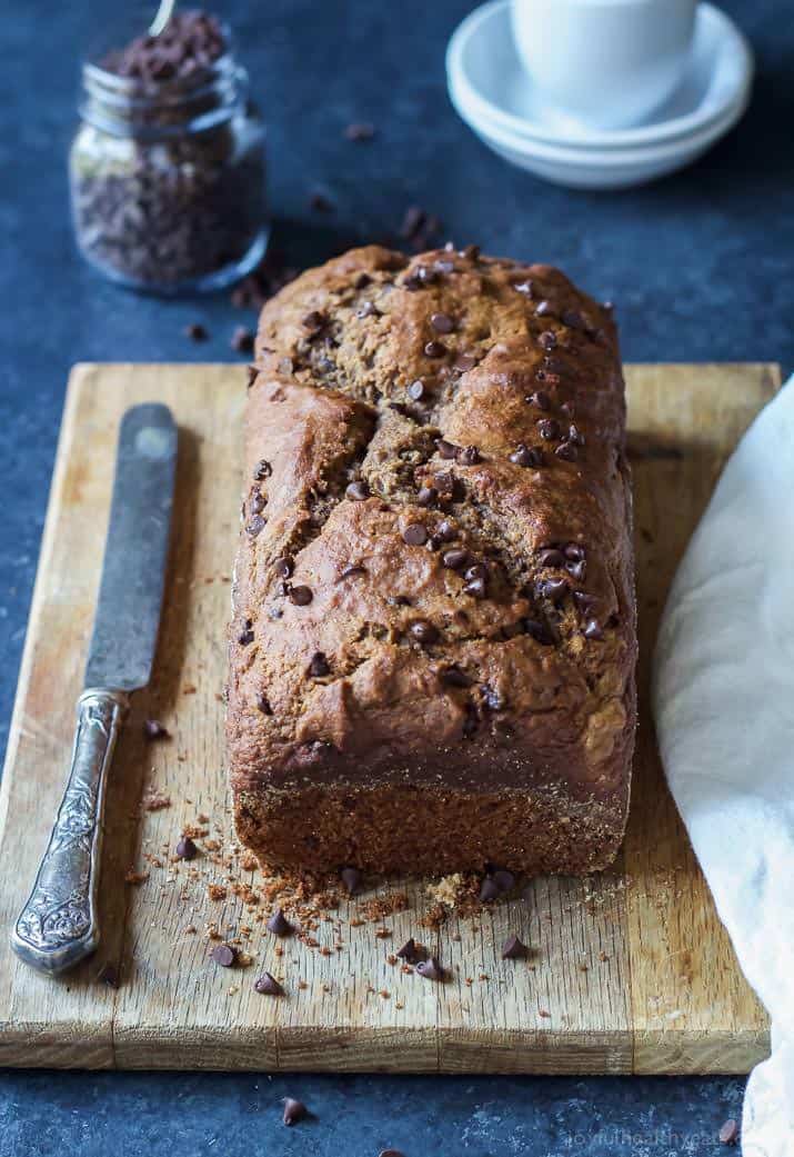 A loaf of Double Chocolate Banana Bread on a wooden cutting board