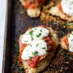 close up photo of baked chicken parmesan on a baking sheet