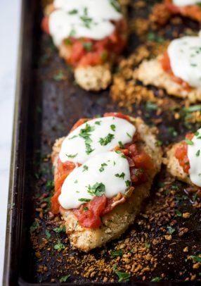 close up photo of baked chicken parmesan on a baking sheet