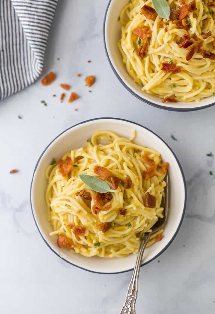 Top view of creamy butternut squash pasta with bacon in a bowl